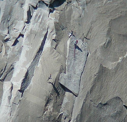 A climber on the King Swing while his partners stand on Boot Flake.