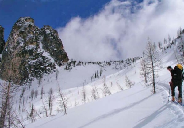 Kurt Hicks approaching the Southwest Couloir under typical early seaso...