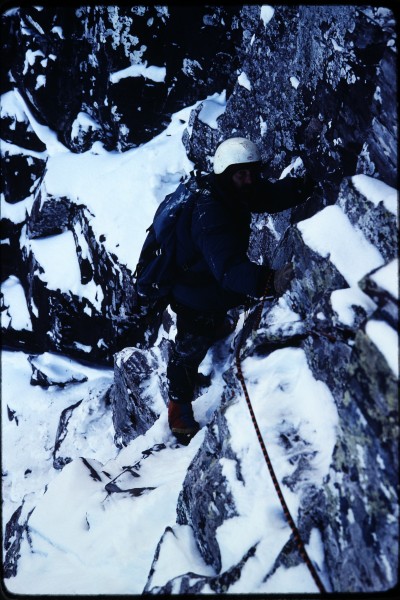 Charlie following on the ledge and cliff system above the snow field.